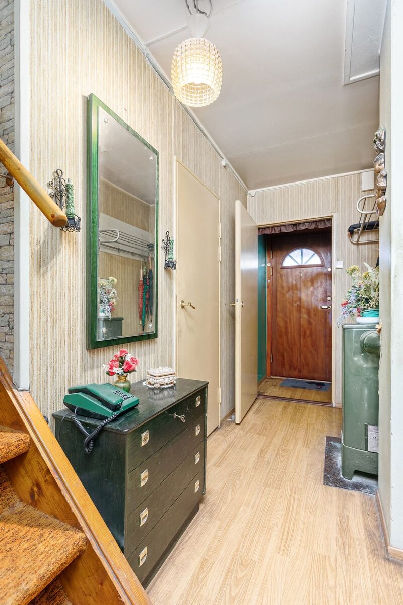 Entryway hall with a framed mirror, a dresser and warm wood tones